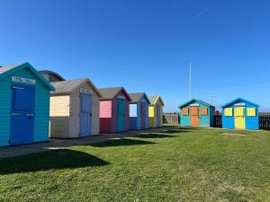 een rij kleurrijke strandhutten op rij bij The Nest at Amble in Amble