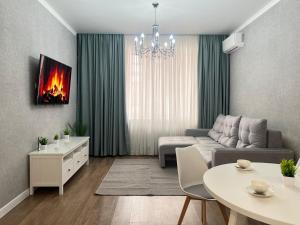 a living room with a couch and a table at Двухкомнатные апартаменты LUX in Pavlodar