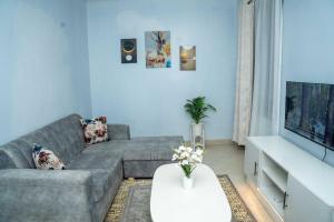 a living room with a gray couch and a white table at Mariehomes in Thika
