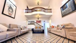 a large living room with couches and a staircase at Casa Pallazzo Luxury Villa - 10BHK Private Pool in Baga +127 photos