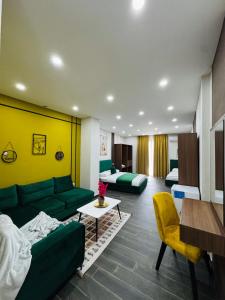 een woonkamer met groene meubels en een gele muur bij Andor Luxury Hotel & Duplex in Durrës