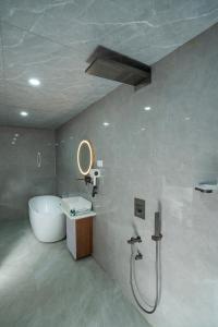 un bagno con vasca, lavandino e doccia di Hotel Sri Ashvik Rameswaram a Rāmeswaram