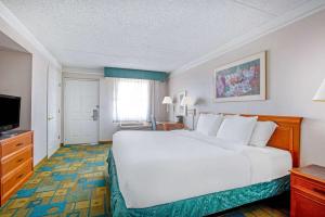 a hotel room with a large white bed and a television at La Quinta Inn by Wyndham Reno in Reno