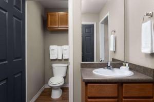 a bathroom with a toilet and a sink at Eagle's Den Suites Kenedy a Travelodge by Wyndham in Kenedy +17 photos