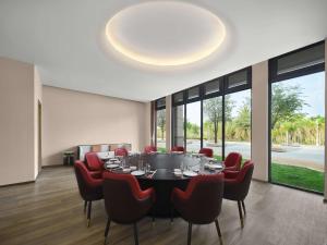 a dining room with a round table and red chairs at Hilton Garden Inn Sanya Haitang Bay in Sanya