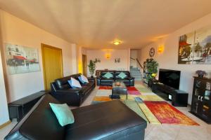a living room with two leather couches and a television at Pianello Bellavista in Pianello Del Lario