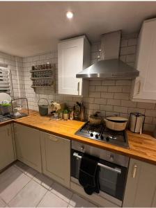 a kitchen with a stove and a counter top at Cosy Cottage 7 mins from Cardiff City Center in Cardiff