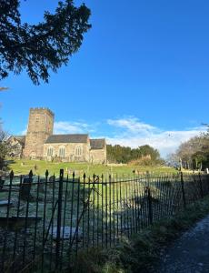 an old building with a fence in front of it at Cosy Cottage 7 mins from Cardiff City Center in Cardiff