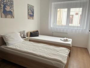 Posteľ alebo postele v izbe v ubytovaní Hungaria Apartments