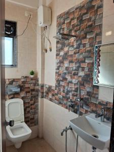 a bathroom with a white toilet and a sink at Wollywood, Wada in Wada