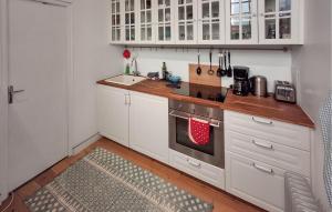 a kitchen with white cabinets and a stove top oven at 2 Bedroom Nice Home In Taden in Taden