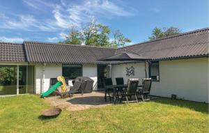 a backyard with a table and chairs and an umbrella at 2 Bedroom Nice Home In Roslev in Roslev +10 photos