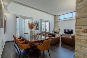 a living room with a glass table and chairs at Kallisti Beach & Spa Villa - A Luxury Seaside Retreat in Lachi
