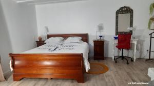 a bedroom with a wooden bed and a red chair at Belle vue in Agde