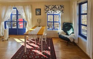 a room with a table and a chair and windows at Cozy Apartment In Larkollen in Laurkollen