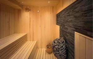 a sauna with a stone wall and a wooden tub at Lovely Home In Aurdal With Sauna in Aurdal +17 photos