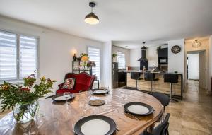 a living room with a table and a kitchen at Cozy Home In Dolus-D'oléron With Wifi in Dolus-d'Oléron