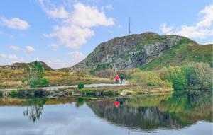 a person walking on a path next to a body of water at Lovely Apartment In Myklebost With Wifi in Myklebost