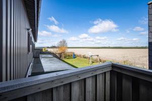a balcony of a house with a view of a field at Ferienwohnungen Hof Am Deich in Hillgroven