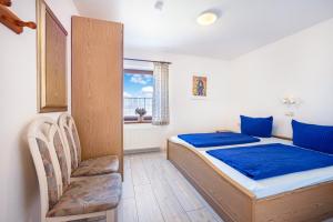 a small bedroom with a bed and a chair at Ferienwohnungen Hof Am Deich in Hillgroven