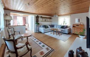 a living room with a couch and a table at Nice Home In Vittsjö With Sauna in Vittsjö