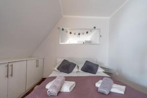 a bedroom with a bed with two pillows and a mirror at WHY NOT Apartamenty widokowe PANORAMA in Kościelisko