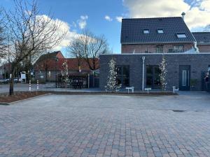 a brick building with white flowers in front of it at Hotel et Möppken in Emlichheim