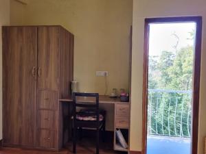 a room with a desk with a chair and a window at Shillong Lyn Homestay in Shillong