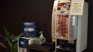 a remote control next to a water machine at Hotel Resh Tottori Ekimae in Tottori