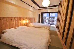 two beds in a room with a window at サンモールクレスト403 in Tokyo
