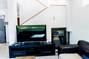 a living room with a flat screen tv and a couch at The Zinkwazi Beach Holiday Home in Zinkwazi Beach