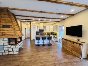 a living room with a fireplace and a flat screen tv at Ferienhaus MILA - Pool, Sauna, Whirlwanne, 5000qm Privatgelände mit Bolzplatz in Striesdorf