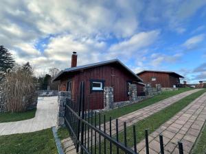 a red barn with a fence in front of it at Ferienhaus MILA - Pool, Sauna, Whirlwanne, 5000qm Privatgelände mit Bolzplatz in Striesdorf