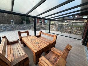 a patio with a wooden table and benches at Ferienhaus MILA - Pool, Sauna, Whirlwanne, 5000qm Privatgelände mit Bolzplatz in Striesdorf
