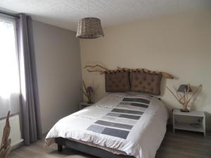 a bedroom with a bed with a wooden headboard at Maison aux portes du centre historique de Dijon avec 3 chambres et garage in Dijon