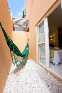 a green hammock hanging from the side of a building at Pousada Eco Maceio in Maceió