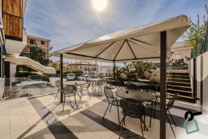 a patio with tables and chairs and an umbrella at HOTIDAY Room Collection - Varazze in Varazze