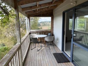 un porche de una casa con mesa y sillas en Cosy Country Private Cottage with views, en Harapepe 14 fotos más
