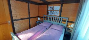 a small bedroom with a bed with purple sheets at Christinas familienfreundliches Ferienhaus, nah Serengeti Park in Neudorf Rodewald
