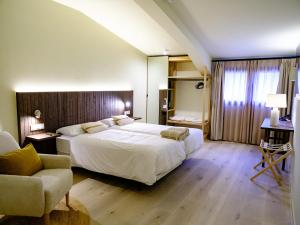 El OsoにあるHotel Rural Casa del Osoの大きな白いベッドと椅子のある寝室