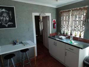 a kitchen with a sink and a counter with stools at Fountain Baths Guest Cottages in Barberton +38 photos