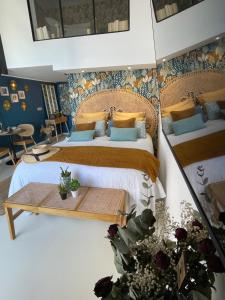 a bedroom with two beds and a table at cala luna spa vue mer , clim, à 50m de la plage , literie luxe , entièrement équipé in Conca +13 photos