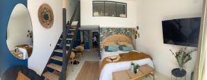 a small bedroom with a bed and a staircase at cala luna spa vue mer , clim, à 50m de la plage , literie luxe , entièrement équipé in Conca