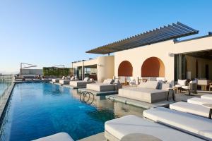 una piscina con sedie a sdraio e un resort di The Muse a Doha