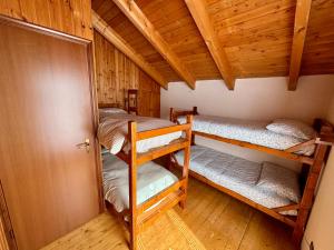 a room with three bunk beds in a cabin at Chalet Caldo & Accogliente a Cheggio "Obrigado House" in Alpe Cheggio