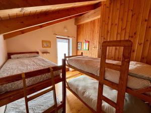 two bunk beds in a room with wooden walls at Chalet Caldo & Accogliente a Cheggio "Obrigado House" in Alpe Cheggio
