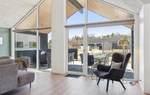 a living room with sliding glass doors and a dining area at Pet Friendly Home In Nørre Nebel in Nørre Nebel