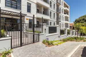 an apartment building with a gate in front of it at Luxury & Tranquility at Alphen Glen Constantia in Cape Town