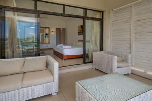 a living room with a couch and chairs and a bed at 4- Bedroom Beachfront Villa in Grand Baie +81 photos
