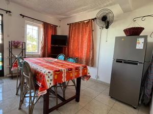 a kitchen with a table and a refrigerator at Villas Floralies in Grand-Baie